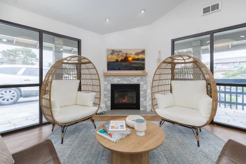 two chairs and a table in a living room with a fireplace at Surfland Hotel in Lincoln City