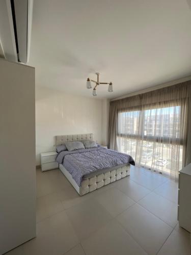 a bedroom with a bed and a large window at Elegant 1BR Chalet at Marassi Marina 2 in El Alamein