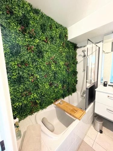 La salle de bains est pourvue d'un mur vert et d'une baignoire. dans l'établissement El Circo foch, à Châlons-en-Champagne