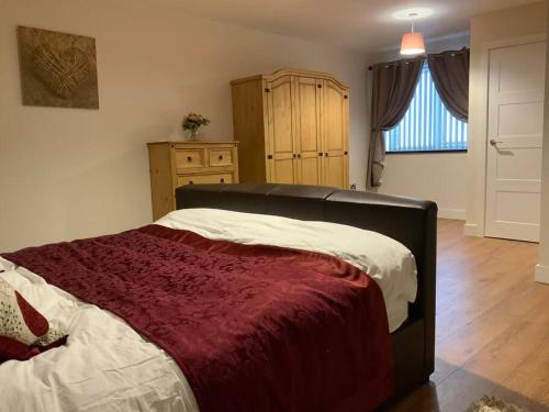 a bedroom with a large bed with a red blanket at St Marks Court Holiday Homes - No1 in Marske-by-the-Sea