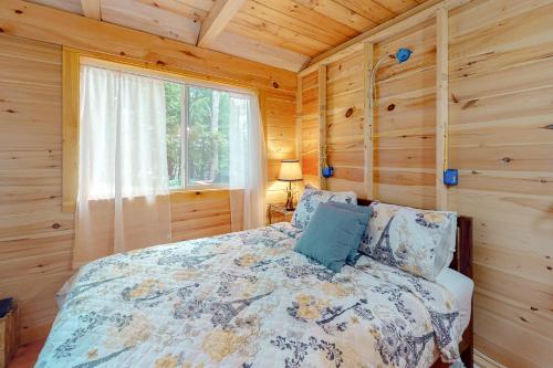 ein Schlafzimmer mit einem Bett in einem Blockhaus in der Unterkunft Loon Cove in Waterville