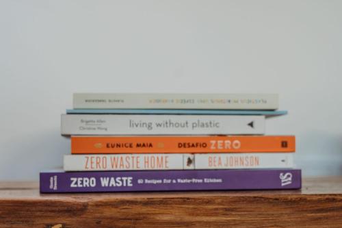 a stack of books sitting on top of a table at Villa Saudade - Sustainable Living in Porto Covo