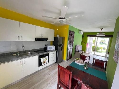 uma cozinha com paredes brancas e verdes e uma mesa em Boca Paraiso em Boca Chica