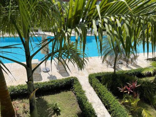 a resort with a pool and palm trees and bushes at Boca Paraiso in Boca Chica