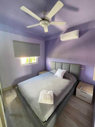 a purple bedroom with a bed with a ceiling fan at Boca Paraiso in Boca Chica