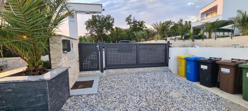 a black gate with trash cans and a fence at Luxury White Sails Villas with a Multi Sport Court #2026# and Sea View in Pinezici