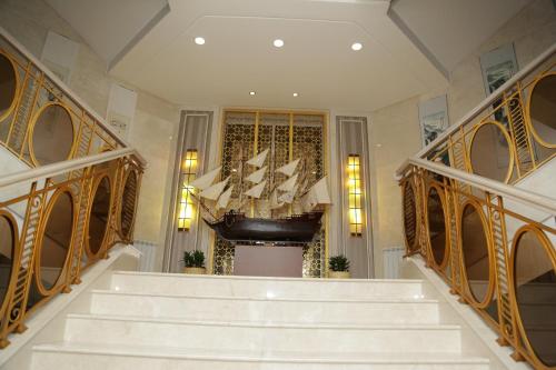 a staircase in a building with a chandelier at Soluxe Hotel Almaty in Almaty