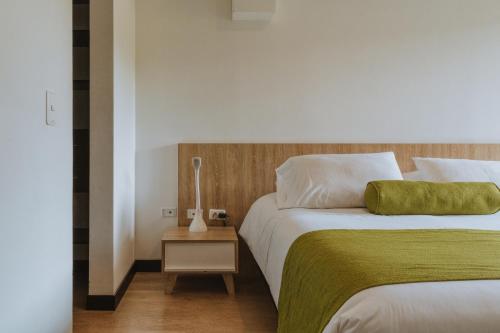 a bedroom with two beds and a lamp on a night stand at Travelers Rio Verde Living Suites in Rionegro