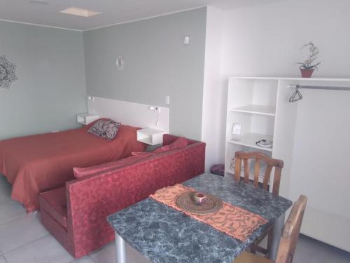 Habitación con sofá, mesa y cama en Departamento 3 Complejo Sol de Oeste en San Juan