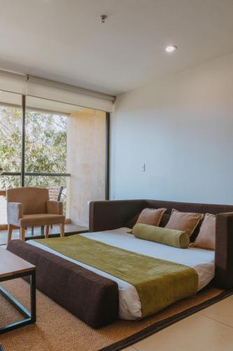 a large bed in a room with a couch at Travelers Rio Verde Living Suites in Rionegro