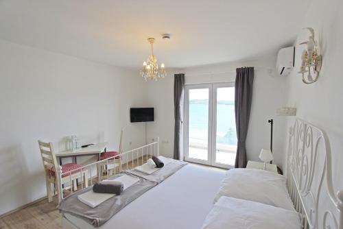 een slaapkamer met 2 bedden, een bureau en een raam bij Villa Danica Murter in Betina