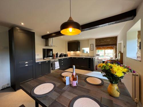 a kitchen with a wooden table and a dining room at Braunston Manor Cottage in Braunston
