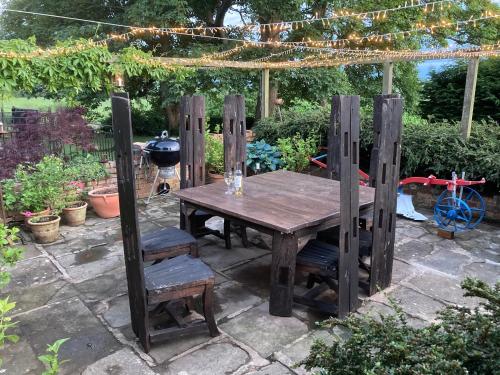 una mesa de madera y sillas en un jardín en Braunston Manor Cottage en Braunston