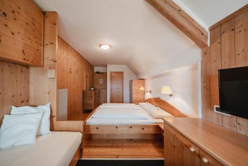 a large room with two beds and a tv at Golfhotel Sonne in Siusi