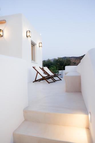 a white house with white stairs and lights at Agapi Home in Agápi