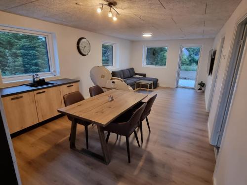 cocina y sala de estar con mesa de madera y sillas en Bonico, en Horsens