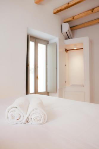a white bed with two towels on top of it at Agapi Home in Agápi