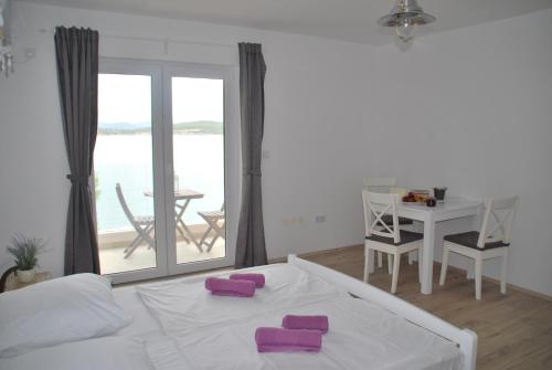 een slaapkamer met een bed met paarse kussens erop bij Villa Danica Murter in Betina