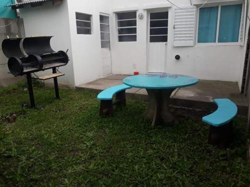 una mesa de picnic y una parrilla en un patio en Departamentos Ale y Cris Cheverrier 304 en Tandil