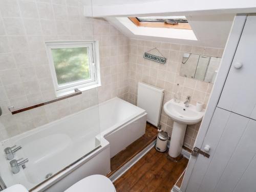 ein Badezimmer mit einer weißen Badewanne und einem Waschbecken in der Unterkunft Lime Cottage in Matlock