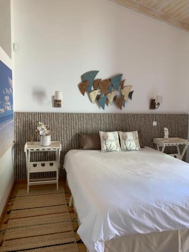 um quarto com uma cama branca e uma mesa lateral em Casa de Férias com piscina - Condominio Vilamouraténis em Vilamoura