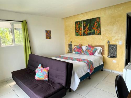 - une chambre avec un lit et un canapé dans l'établissement Rinconcito Verde, à Ujarrás