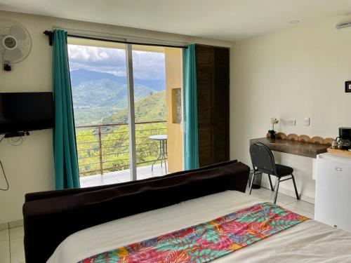 - une chambre avec un lit et une grande fenêtre dans l'établissement Rinconcito Verde, à Ujarrás