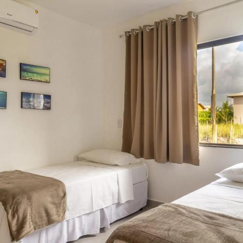 - 2 lits dans une chambre avec fenêtre dans l'établissement Camboa Village, à Barra Grande