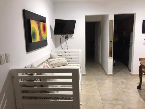 a white room with a bed and a tv on a wall at Solo Se Trata De Vivir in Tandil