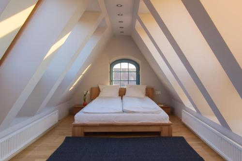 Schlafzimmer im Dachgeschoss mit einem Bett und einem Fenster in der Unterkunft Villa Pica Paca - Old Town in Danzig