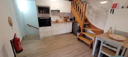 a kitchen with a staircase in a small room at Casa Cereja in Pêro Viseu