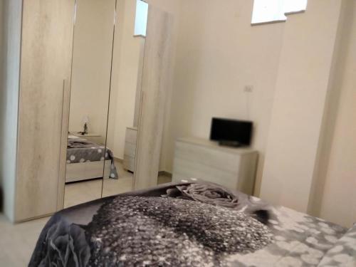 - une chambre avec un miroir, un lit et une télévision dans l'établissement CASA RED ROSE, à Maddaloni