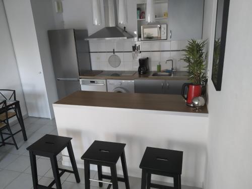 uma cozinha com balcão e bancos em A Poitiers, 2 chambres, très bel appartement de 65 m2 em Poitiers