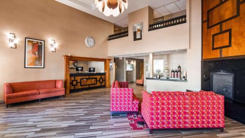 a lobby with red chairs and a fireplace at Best Western Plus Peoria in Peoria