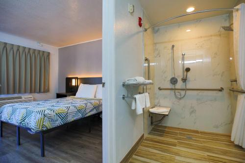 um quarto de hotel com uma cama e um chuveiro em Motel 6-Sacramento, CA - Old Sacramento North em Sacramento