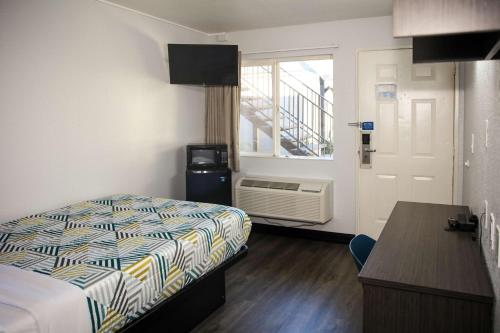 a room with a bed and a kitchen with a window at Motel 6-Sacramento, CA - Old Sacramento North in Sacramento