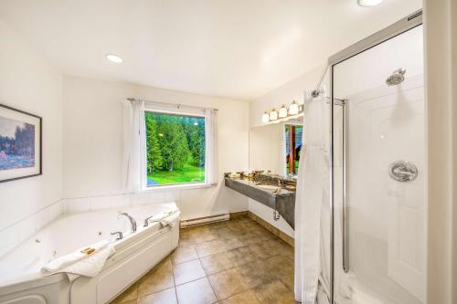 een badkamer met een bad, een douche en een wastafel bij Kootenay Lakeview Resort BW Signature Collection in Balfour