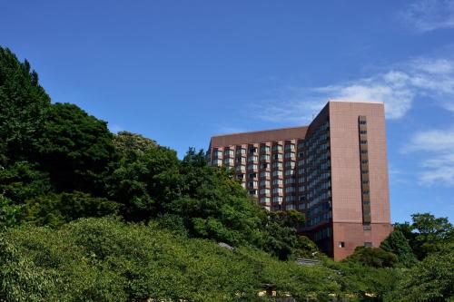 a tall building with trees in front of it at Hotel Chinzanso Tokyo in Tokyo