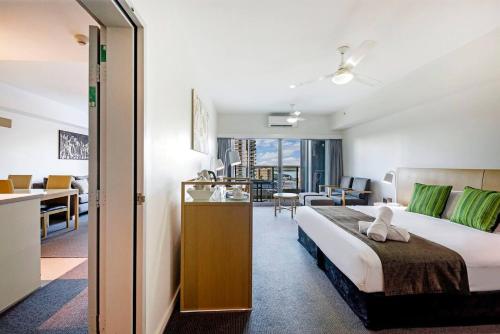 a hotel room with a bed and a living room at Two Resort-style Suites - Moments to Waterfront Precinct in Darwin