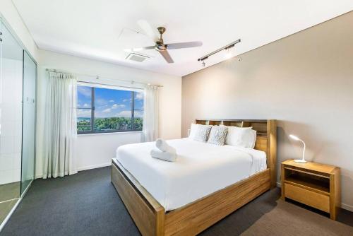 a bedroom with a large bed and a window at Top of Timor Sea A Luxury Waterfront Penthouse in Darwin