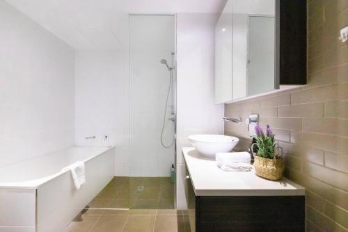 a bathroom with a sink and a toilet and a tub at Top of Timor Sea A Luxury Waterfront Penthouse in Darwin
