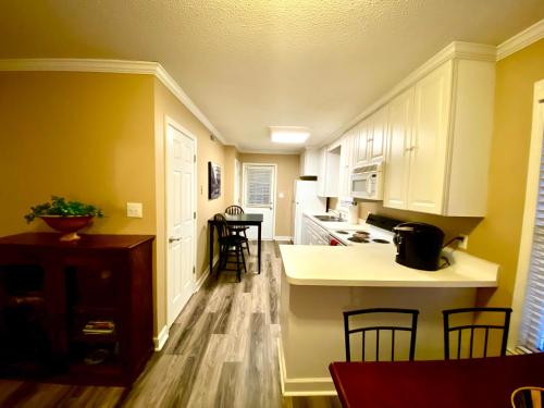 a kitchen with white cabinets and a table and chairs at Trendy 2Bed 2 Bath Villa In The Village With King Bed in Raleigh