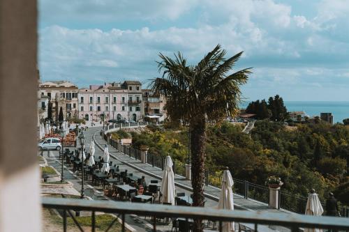 a view of a street with umbrellas and a palm tree at Panphilia: Holiday Apartment in Vasto