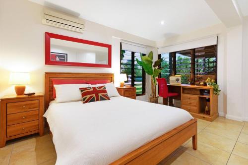 um quarto com uma cama, uma secretária e um espelho em Grand Poolside Getaway in a Parap Paradise Estate em Paraparap