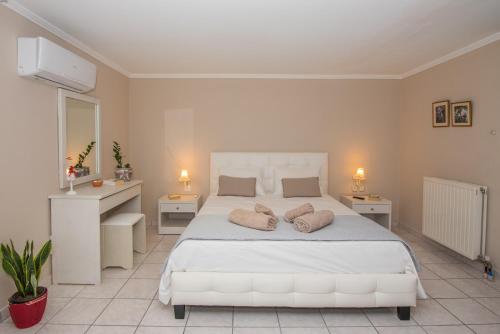 una camera da letto con un letto bianco con due cuscini sopra di La Maison di Angelo 2 Apartment Zakynthos Island ad Áyios Kírikos