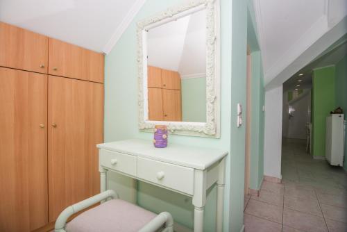 - une coiffeuse avec un miroir et une chaise dans la chambre dans l'établissement La Maison di Angelo 2 Apartment Zakynthos Island, à Áyios Kírikos