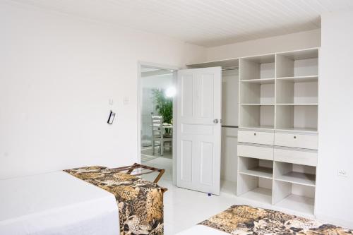 a white room with a closet and a chair at EL BORSALINO - Apartamento en Amazonas, Leticia in Leticia