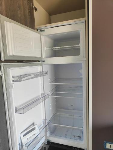 an empty refrigerator with its door open in a kitchen at Fantasia B&B APARTAMENT STUDIO in Pellaro