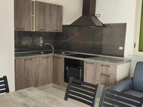 a kitchen with wooden cabinets and a stove top oven at Fantasia B&B APARTAMENT STUDIO in Pellaro