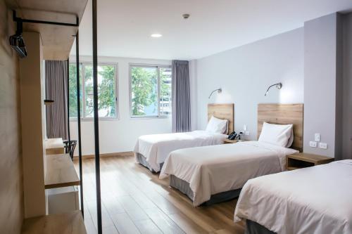 um quarto de hotel com duas camas e duas janelas em The Park Hotel em Guayaquil